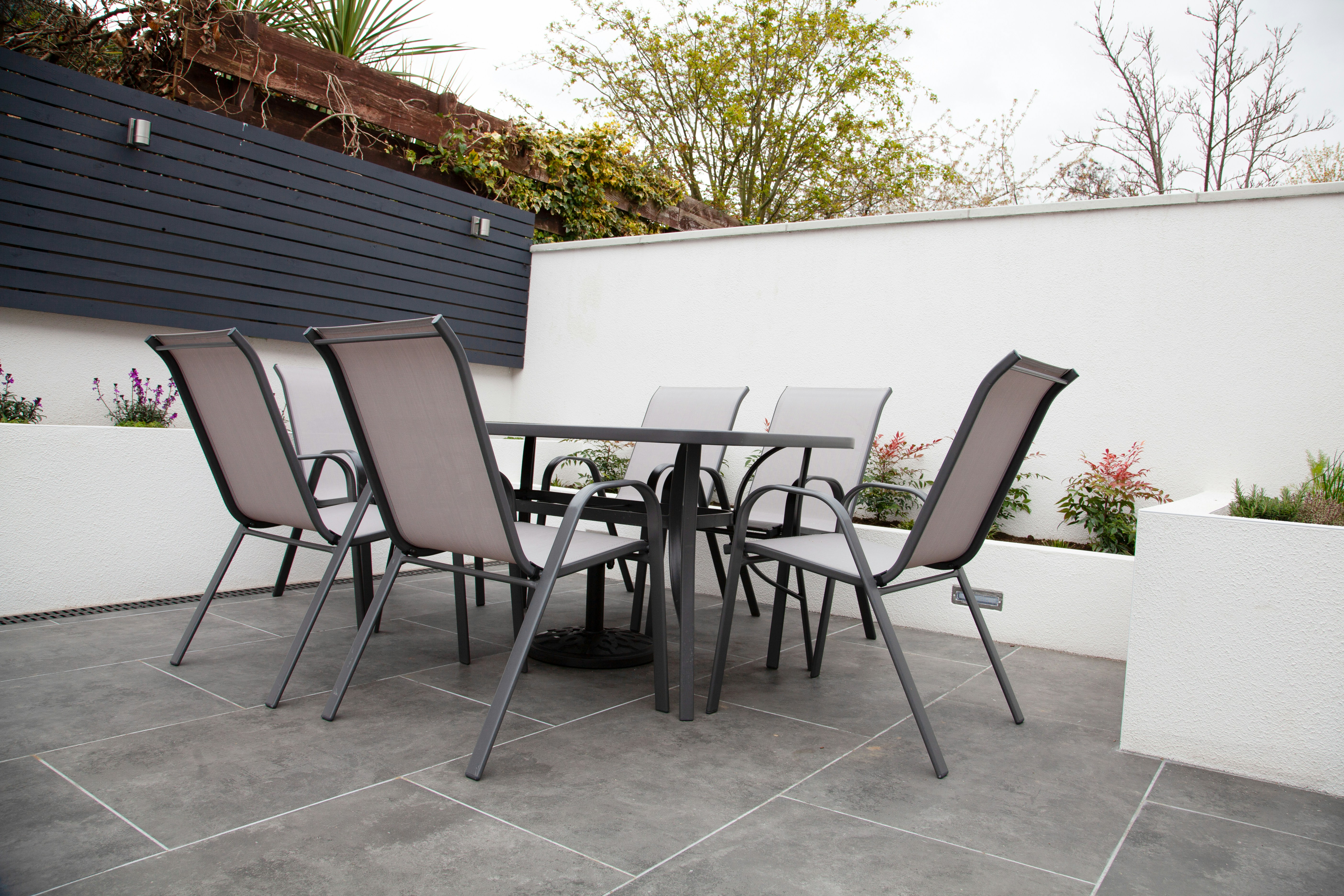 Table and chairs in a small garden.