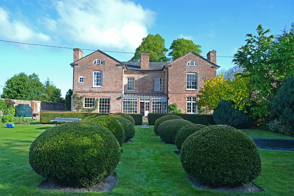 House with pruned hedges.